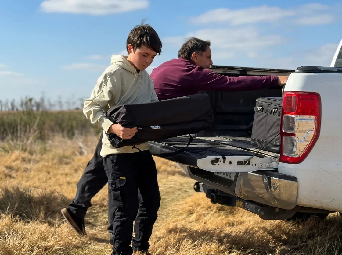 Dos personas cargando el equipo en una camioneta antes de salir